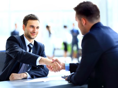 Two business colleagues shaking hands during meeting