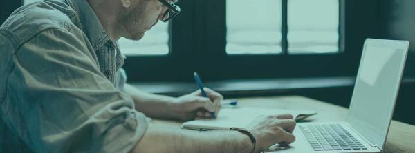 Man at desk exploring cover letter templates on laptop.