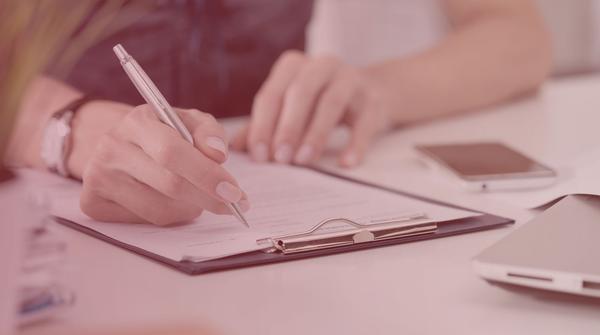 Hands writing on a cover letter format page.